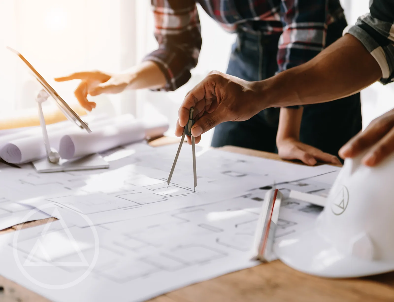 Architects measuring loft floor plans with a compass