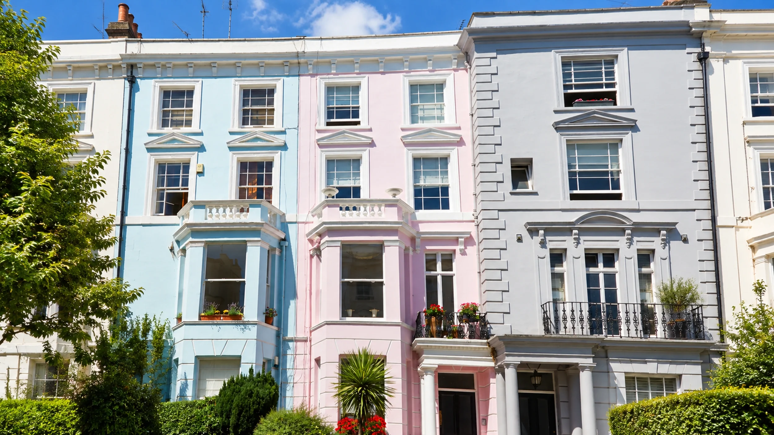 Pastel-painted stucco terrace in a London conservation area with iron balconies and columned porches