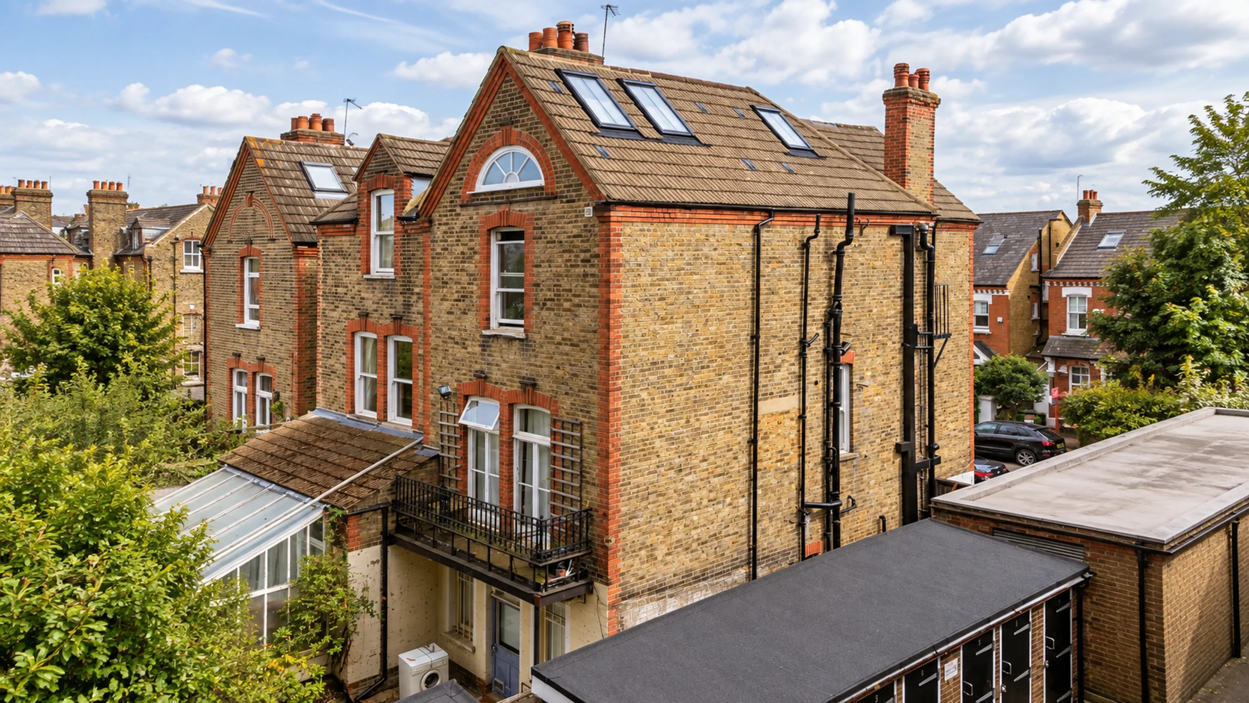 Large converted Victorian villa of flats seen from above, with rooflights across the tiled roof