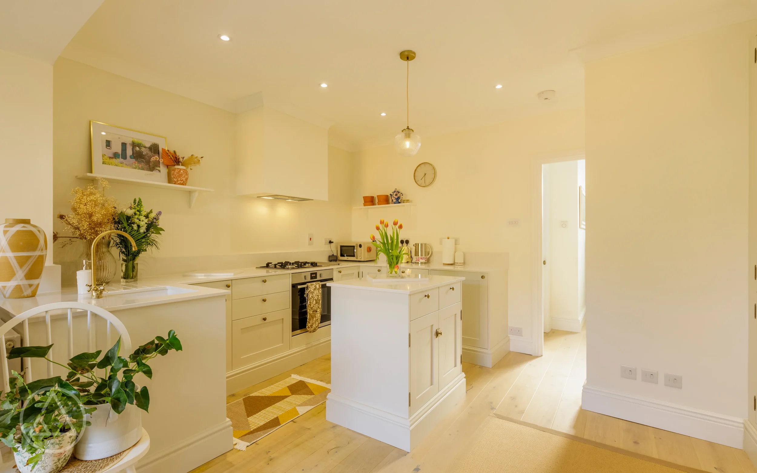 Cream shaker kitchen with island, brass tap and oak flooring, looking towards the hallway on Nelson Road