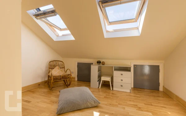 Loft room with two pine-framed rooflights, a built-in eaves desk and two storage doors