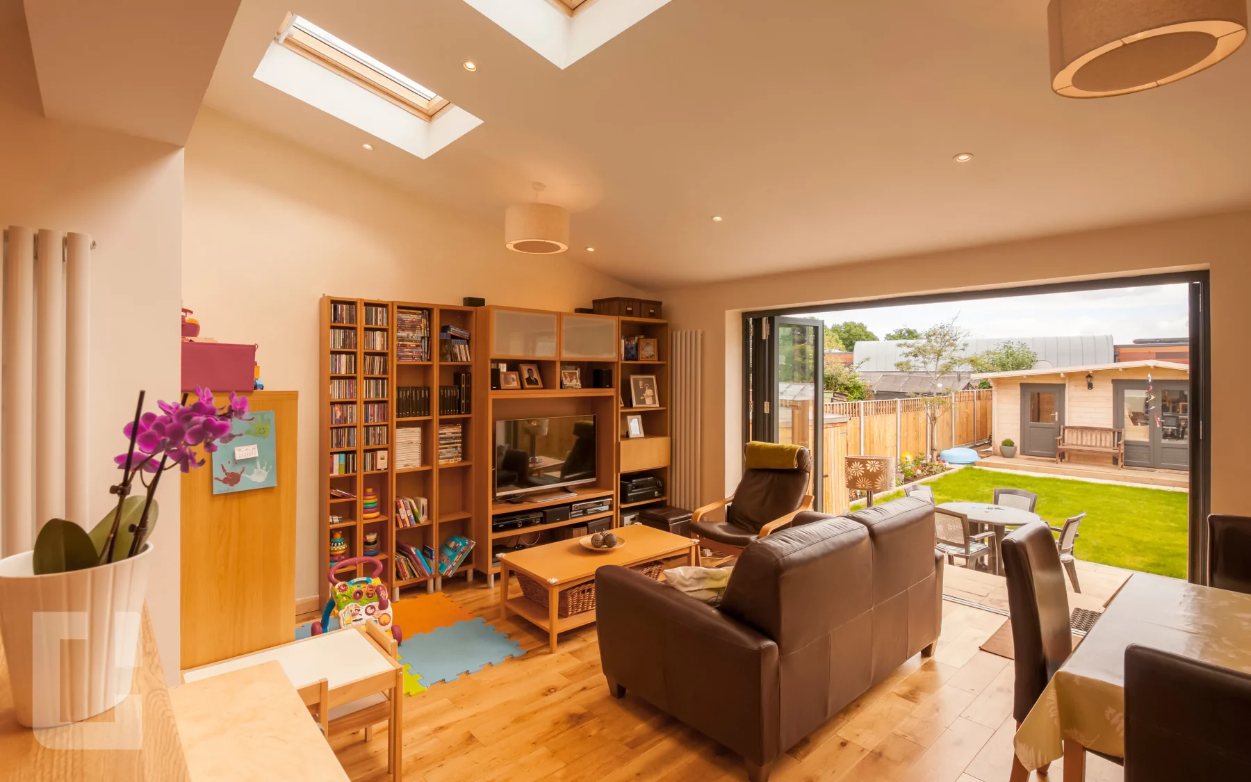 Open-plan rear extension living room in Islington with rooflight and bi-fold doors open to the garden