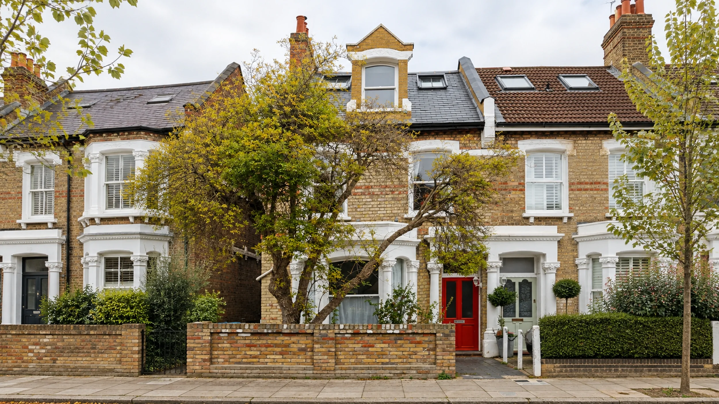 Victorian yellow stock brick terrace with a gabled dormer loft conversion and rooflights next door